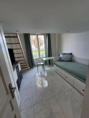 a bedroom with a bed and a table and a window at 2 pièces promenade des anglais in Nice