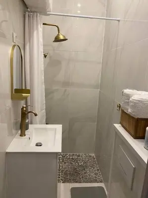 a white bathroom with a shower and a sink at Appartement tout confort, agréable à vivre in Nice