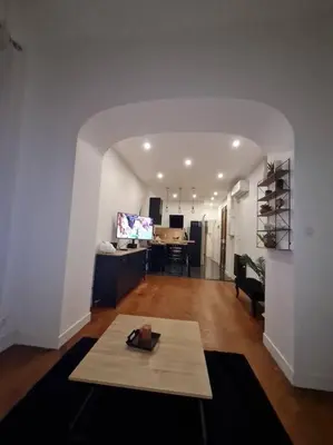 a living room with a table in the middle of a room at Appartement tout confort, agréable à vivre in Nice