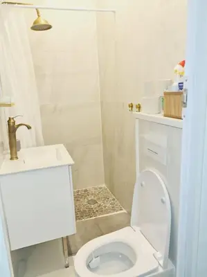 a white bathroom with a toilet and a sink at Appartement tout confort, agréable à vivre in Nice