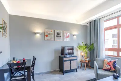 a living room with a tv and a table and a chair at L12 Port window 1Bedroom Wifi 5mins beach & Nice's Cap in Nice