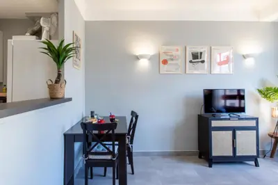 a dining room with a table and a tv at L12 Port window 1Bedroom Wifi 5mins beach & Nice's Cap in Nice