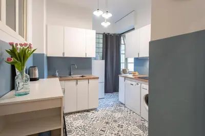 a kitchen with white cabinets and a vase of flowers at L14 2P Promenade Vue Mer climatisé, spacieux/ Balcon in Nice
