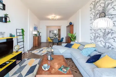 a living room with a blue couch and a table at L14 2P Promenade Vue Mer climatisé, spacieux/ Balcon in Nice