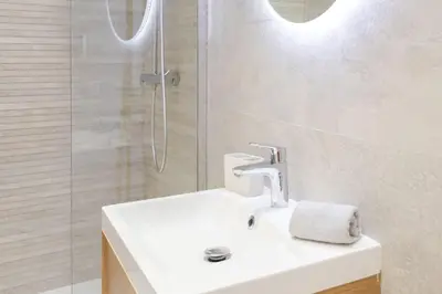 a white bathroom with a sink and a shower at L16 Suite Malonat Vieux Nice 1 min Mer/ 2 chbres & AC in Nice
