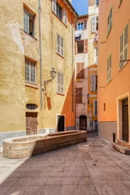 an alley with a fountain in the middle of a building at L16 Suite Malonat Vieux Nice 1 min Mer/ 2 chbres & AC in Nice