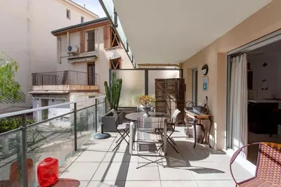 a patio with a table and chairs on a balcony at L18 Central Parking terrace AC 10mins walk to beaches in Nice