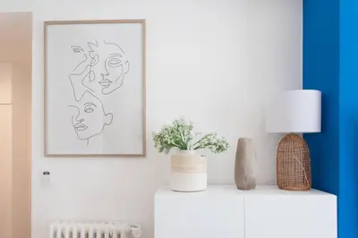 a living room with a painting of faces on the wall at L24 Meyerbeer Promenade 1min SEA & Negresco AC/Balcony in Nice