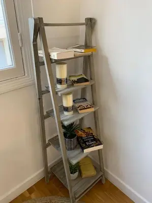 a ladder shelf in a room with books at L24 Meyerbeer Promenade 1min SEA & Negresco AC/Balcony in Nice