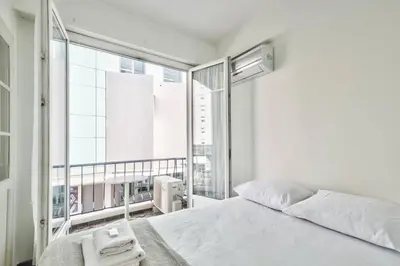 a bedroom with a white bed and a large window at L29 Lenval beach at 1min walk to Sea front AC Balcony in Nice