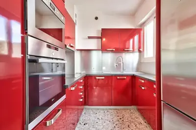 a red kitchen with red cabinets and a sink at L29 Lenval beach at 1min walk to Sea front AC Balcony in Nice