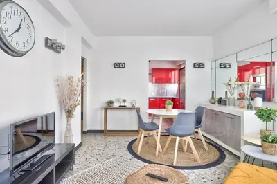 a kitchen with a table and chairs and a clock at L29 Lenval beach at 1min walk to Sea front AC Balcony in Nice