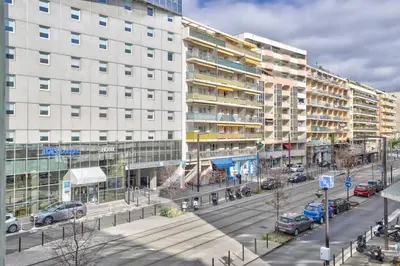 a city street with cars parked in front of buildings at L29 Lenval beach at 1min walk to Sea front AC Balcony in Nice