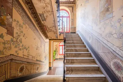 a staircase in a building with paintings on the walls at Appartement Atypique cœur de ville -AC- in Nice