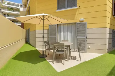 a table and chairs with an umbrella on a patio at Joli 2 pièces Niçois avec terrasse ensoleillée in Nice