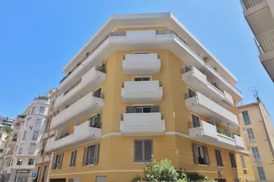 a tall yellow building with white balconies at Joli 2 pièces Niçois avec terrasse ensoleillée in Nice