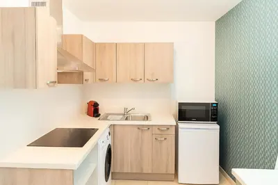 a small kitchen with a sink and a microwave at Joli 2 pièces Niçois avec terrasse ensoleillée in Nice