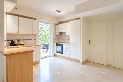 a kitchen with white cabinets and a counter top at L34 Hermès Suite terrace parking AC 2mins SEA in Saint-Jean-Cap-Ferrat