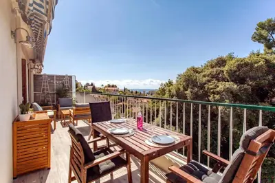 a patio with a table and chairs on a balcony at L36 Sea view terrace 10min walking to sea/Parking & AC in Nice