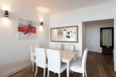 a dining room with a table and white chairs at L39 Suite Promenade des Anglais, Vue Mer Terrasse&WIFI in Nice