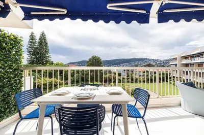 a white table and chairs on a balcony with a view at FEEL HOME - GRASSEUIL in Saint-Jean-Cap-Ferrat