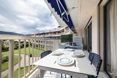 a white table and chairs on a balcony at FEEL HOME - GRASSEUIL in Saint-Jean-Cap-Ferrat