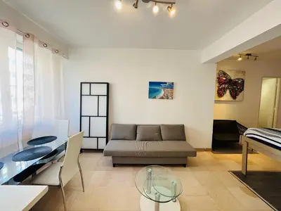 a living room with a couch and a glass table at Grand studio de 30 m2 Promenade des Anglais in Nice