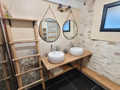 a bathroom with two sinks and two mirrors at Chaleureuse bergerie rénovée. in Tourrette-Levens