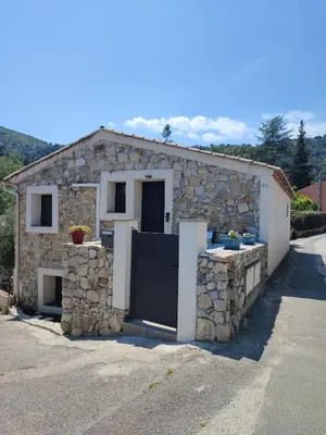 a stone house with a door and a stone wall at Chaleureuse bergerie rénovée. in Tourrette-Levens