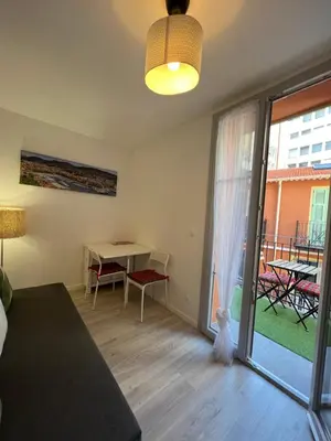 a room with a bed and a table and a window at La cour du centre Nice Verde in Nice