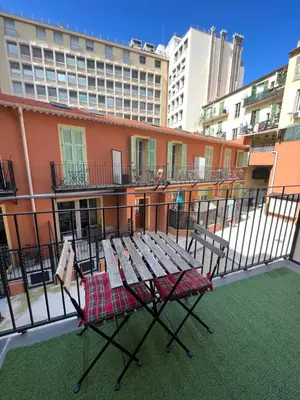 a picnic table on the balcony of a building at La cour du centre Nice Verde in Nice
