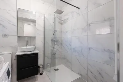 a bathroom with a glass shower and a sink at Pretty Studio Swimming pool and Sea in Cagnes-sur-Mer
