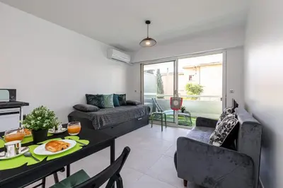 a living room with a table and a couch at Pretty Studio Swimming pool and Sea in Cagnes-sur-Mer