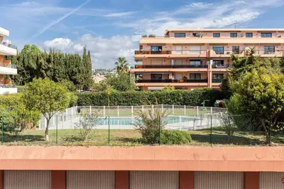 a tennis court in front of a building at Pretty Studio Swimming pool and Sea in Cagnes-sur-Mer