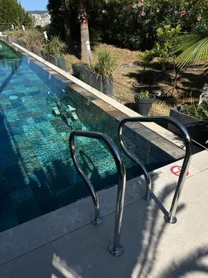 a swimming pool with a bench next to it at COTTAGE MARIN avec VUE MER in Nice