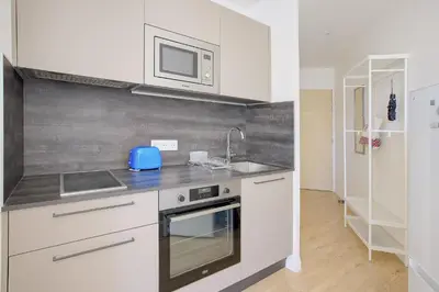 a kitchen with white cabinets and a sink and a microwave at Maison Bianchi - Lamartine in Nice