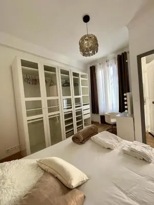 a bedroom with a large white bed and a chandelier at Nice - Appartement T3 rénové de 50 M2 classé 2 étoiles in Nice